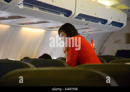 Eine Flugbegleiterin Air Asia chats mit einem Passagier auf einem Flug von Johor Bahru nach Kuching in Sarawak Stockfoto