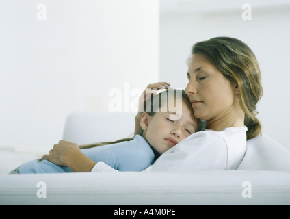 Mädchen schläft auf Frau Brust Stockfoto