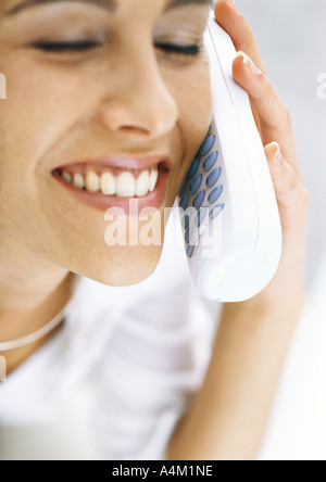 Schnurlos telefonieren mit geschlossenen Augen, lächelnde Frau Stockfoto