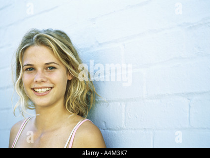 Teenager-Mädchen Ziegelwand gelehnt, Blick in die Kamera, Porträt Stockfoto