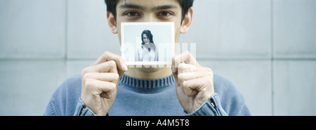 Junger Mann mit Foto der jungen Frau Stockfoto