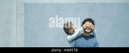 Junge Frau des jungen Mannes Augen bedecken Stockfoto