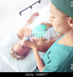 Ärztin mit Sauerstoffmaske über Gesicht des Patienten, erhöhte Ansicht Stockfoto