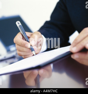 Geschäftsmann unterschreiben am Schreibtisch, close-up der Hände Stockfoto