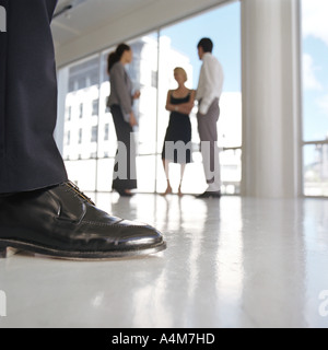 Gut gekleideter Mann Bein, gut gekleidete Gruppe stehen in der Nähe von Fenster Stockfoto