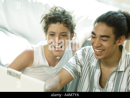 Junges Paar Blick auf Laptop, Lächeln Stockfoto