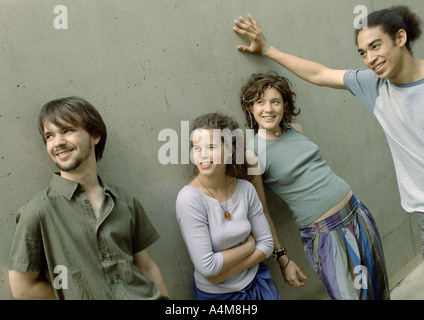 Vier junge Freunde stehend nahe bei der Wand Stockfoto