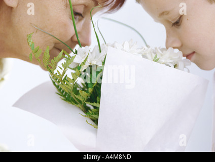 Großmutter und Enkel riechen Blumenstrauß Stockfoto
