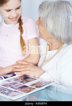 Großmutter und Enkelin Magazin zusammen betrachten Stockfoto