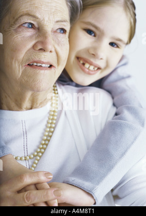 Mädchen umarmen Großmutter, portrait Stockfoto