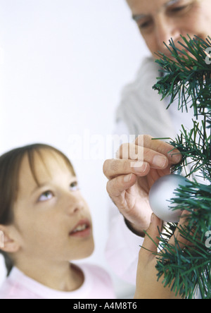 Mädchen und Großvater schmücken Weihnachtsbaum Stockfoto