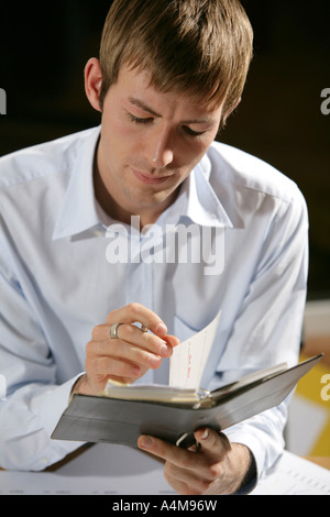 DEU Mann blickt durch seine agenda Stockfoto