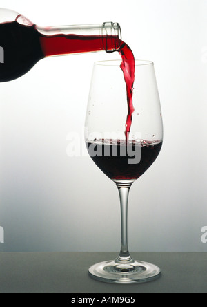 Gießen ein Glas Rotwein Stockfoto