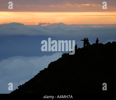 Menschen beobachten Sonnenaufgang über den Wolken aus dem Haleakala Krater in Maui, Hawaii Stockfoto