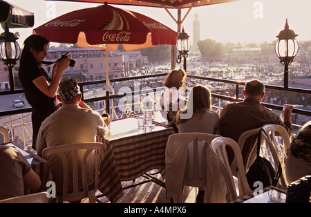 Familie auf Urlaub im Restaurant auf der Dachterrasse mit Blick auf den Platz Djemaa El Fna entfernt. Sonnenuntergang. Marrakesch, Marokko Stockfoto