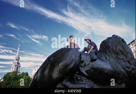 UK ENGLAND LONDON junges Paar sitzt auf Statue Löwen am Trafalgar Square Stockfoto