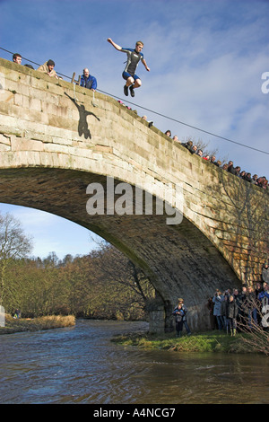 Der Neujahrstag Brücke springen in Fluss Dove von Okeover Brücke, Mappleton, in der Nähe von Ashbourne, Peak District, Derbyshire, England Stockfoto