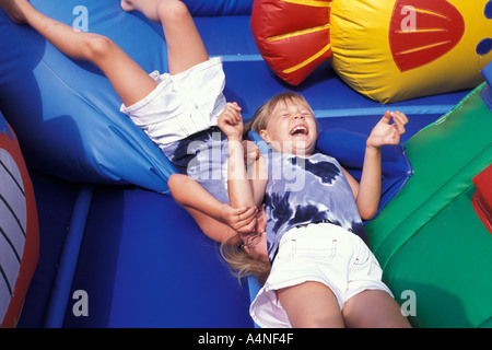 Zwei Kinder spielen auf einem springenden Spielzeug auf einer Messe in Kanada Stockfoto