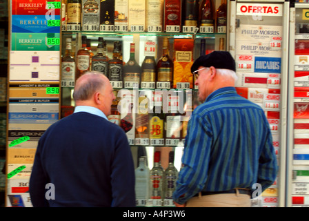 zwei Männer zollfrei Tabak Shop gutes Geschäft Fenster Alkohol Zigaretten Zigarette Rabatt billige Schnäppchen Handel Handel alte Männer Rentner Stockfoto