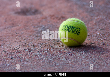 Tennisball auf ein Kies-Oberfläche Stockfoto