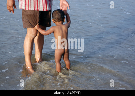 ANG77700 indische Kind und Grand Vater stehen im Meerwasser Goa Indien Stockfoto
