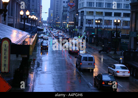 Autos fahren durch eine belebte Kreuzung auf einen Regen und nassen Nacht Downtown Chicago IL USA Stockfoto