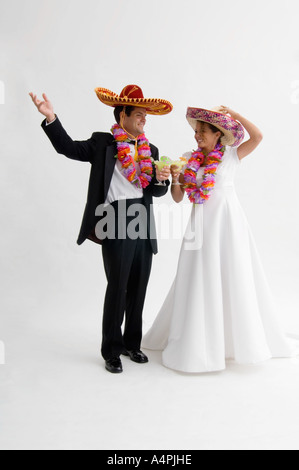 Braut und Bräutigam trägt Sombreros und Leis und hält margarita Stockfoto