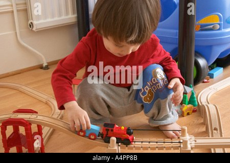 Kleiner Junge spielt mit Züge Stockfoto