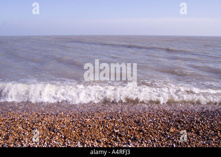 Wellen brechen sich an den Kiesstrand bei Dungeness an der Küste von Kent Stockfoto