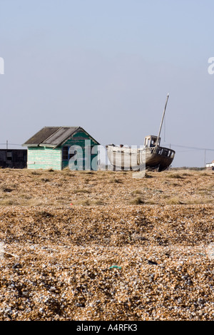 Hölzerne Angelboot/Fischerboot neben einer verfallenen grüne Hütte auf den Kiesstrand bei Dungeness in Kent aufgegeben. Stockfoto