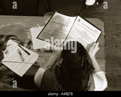Eine junge Frau schaut über das Menü in einem Coffee-shop Stockfoto