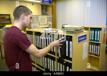 junge Studentin, die Recherche in den lokalen Aufzeichnungen Büro Lancashire ziehende Buch Stockfoto