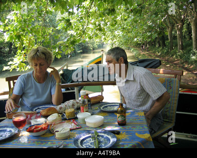 Paar genießt Mittagessen an Bord ihres Schiffes auf dem Canal du Midi, Südfrankreich Stockfoto