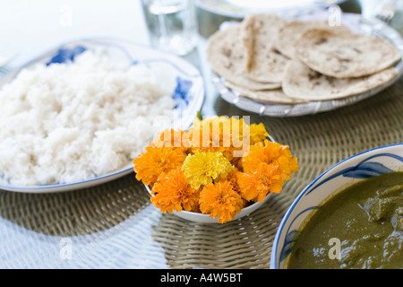 Schale mit Blumen und Essen auf Tisch Stockfoto