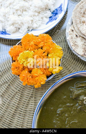 Schale mit Blumen und Essen auf Tisch Stockfoto