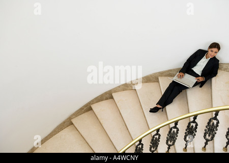 Geschäftsfrau mit Laptop auf Treppe Stockfoto