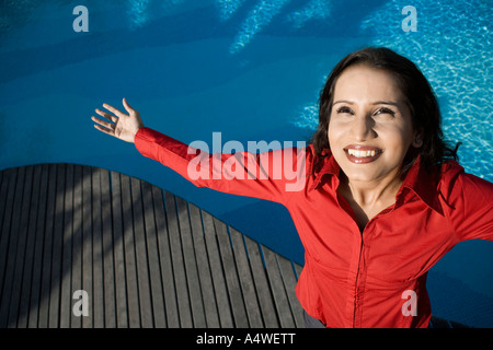 Geschäftsfrau, stehen am Swimmingpool mit ausgestreckten Armen Stockfoto