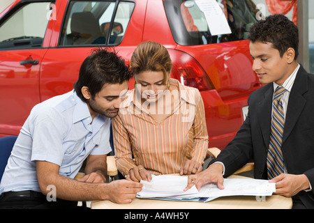 Paar Unterzeichnung Papiere, neues Auto kaufen Stockfoto