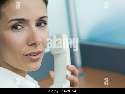 Frau hält Telefon und sprechen über die Schulter Stockfoto