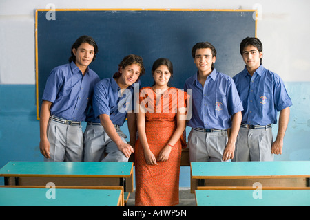 Lehrer, die lächelnd mit männlichen Studenten im Klassenzimmer Stockfoto