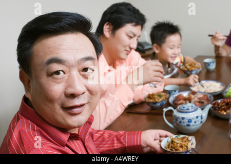 Mann mittleren Alters mit Familie am Tisch sitzen Stockfoto