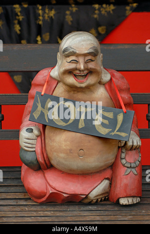 Glücklich lachende Buddhist wie Statue mit einem Schild Werbung HOTEL eines der sieben glücklichen Götter Koh Samui Thailand Stockfoto