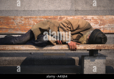 Obdachloser auf Bank In London schlafen Stockfoto