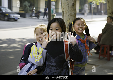 CHINA WUHAN drei junge chinesische Schulmädchen auf dem Heimweg von der Schule Stop für eine touristische s Kamera Lächeln Stockfoto