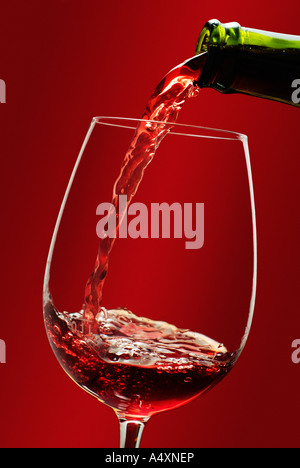 Rotwein wird in ein Glas gegossen Stockfoto