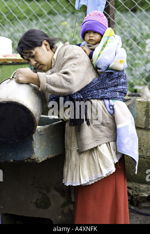 GUATEMALA CAPELLANIA Young indigenen Maya-Quiche Mutter in traditioneller Kleidung wäscht Gerichte Stockfoto