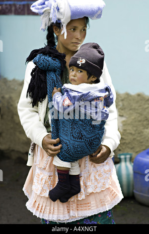 GUATEMALA CAPELLANILLA schöne junge gekleidet traditionell Maya Quiche-Mutter mit ihrem kranken Baby in einem handgewebten Riemen Stockfoto