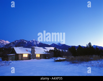 Ranch Hütte im Winter, leuchtet in der Dämmerung Absaroka Berge im Hintergrund Paradise Valley Montana USA Property Release windows Stockfoto