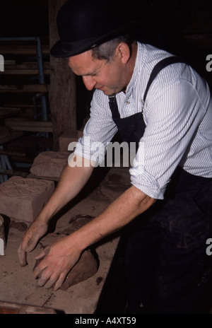 Colin Richards die Ziegel von hand funktioniert des Tons vor dem setzen es in die Form Stockfoto