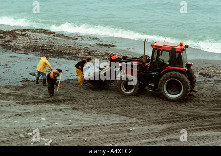 Traktor und Handwerker Reinigung eingeölt Strand Bigbury am Meer UK Stockfoto